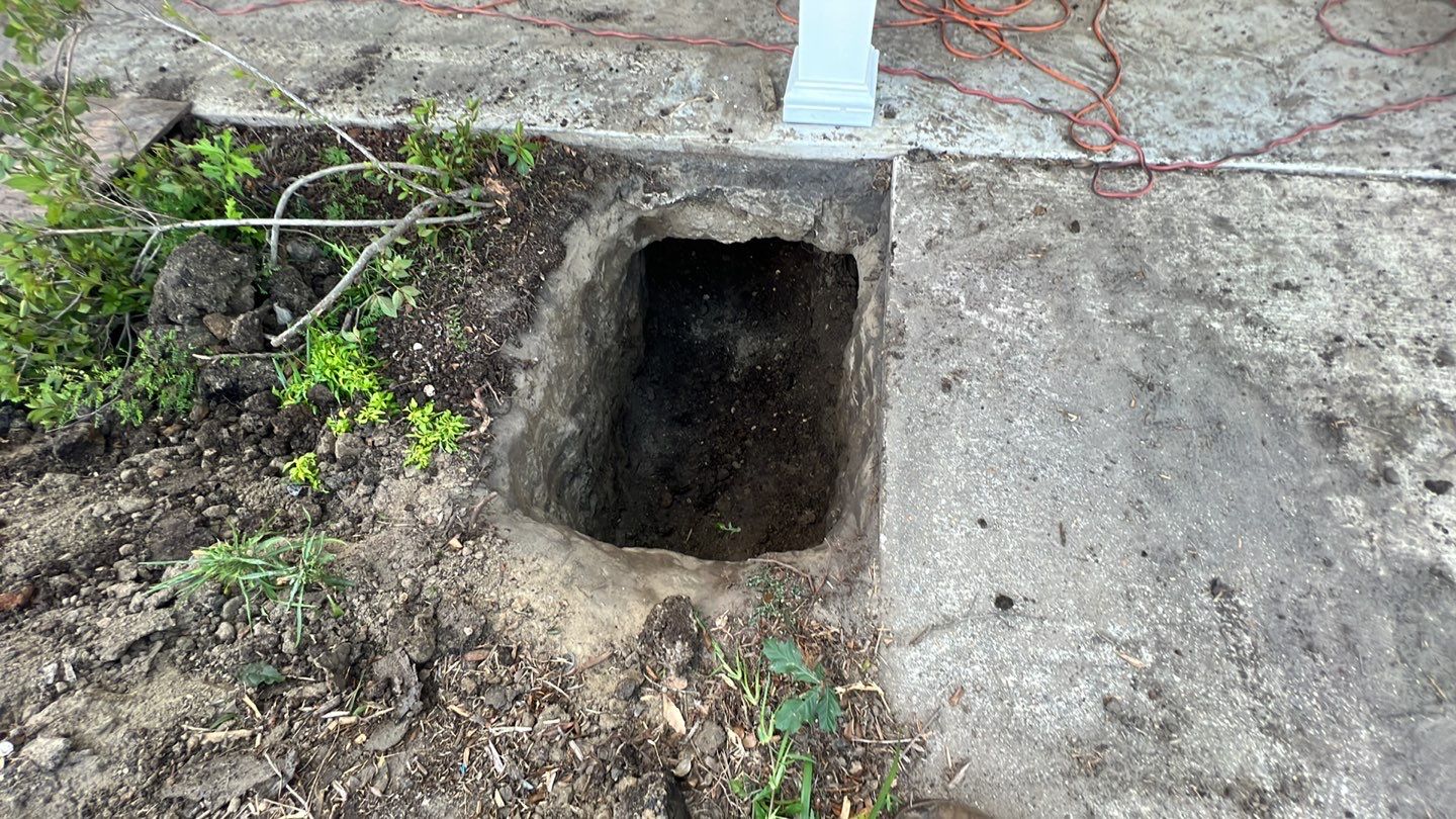 A house with an uneven foundation due to a hole next to it.