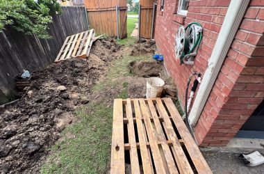 A backyard with dirt on the ground.