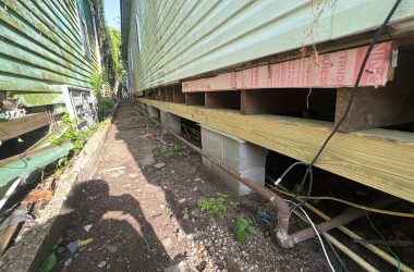 A house with rotting siding and a leaking roof in need of foundation repair.