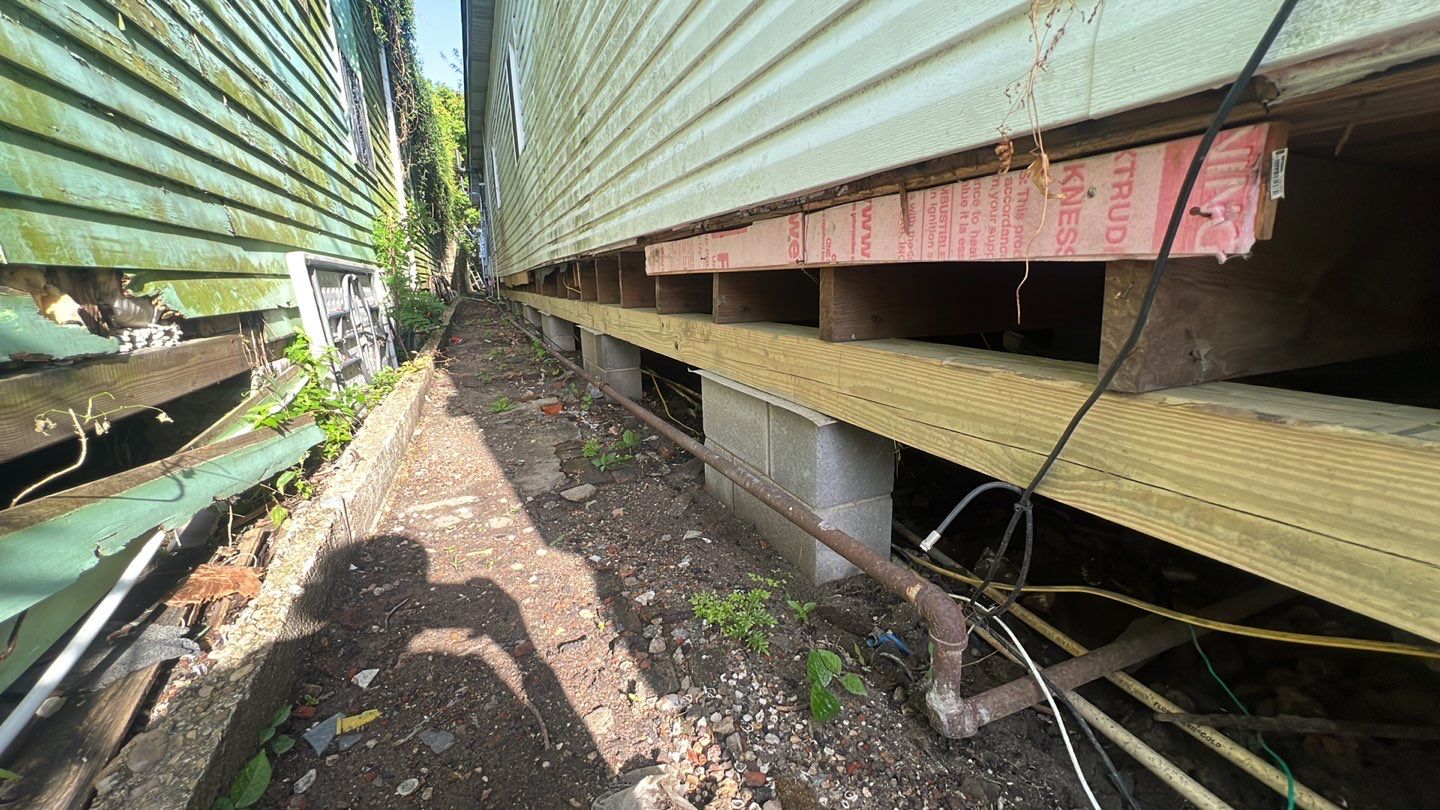 A house with rotting siding and a leaking roof in need of foundation repair.