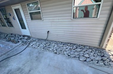 A house with a foundation repair and rocks in front of it.