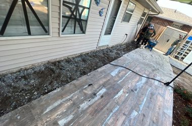 A wooden deck is being built in front of a house for home elevation.