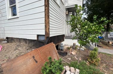 An american flag is on the side of a house.