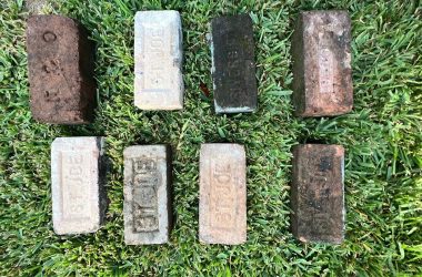 Old bricks laying on the grass, potentially needing foundation repair.