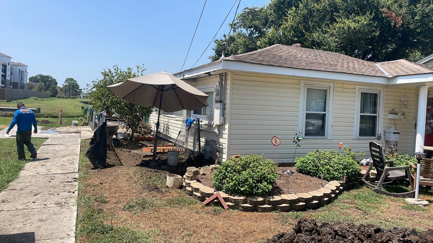 A small backyard with a lawn mower and an umbrella needing foundation repair.