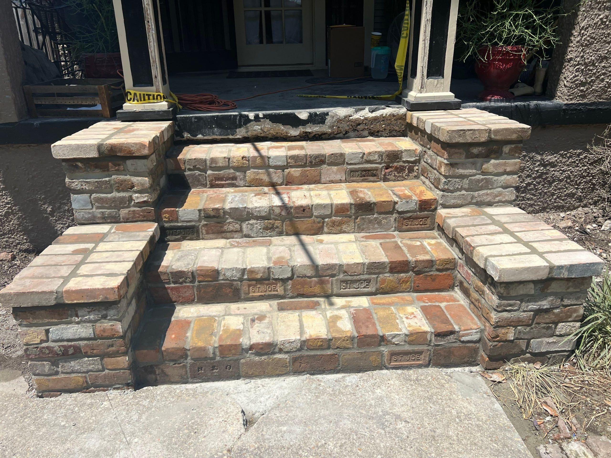 A set of brick steps leading to a front door with Foundation Repair.