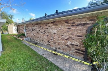 A brick house with a caution tape around it.