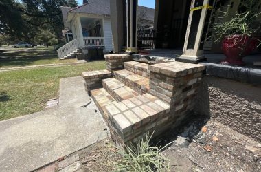 A house with brick steps and foundation repair in front of it.
