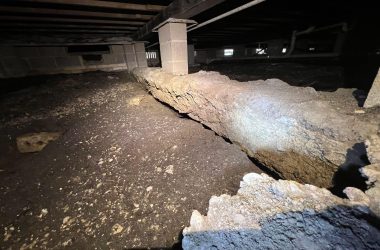 A basement with a large rock in the middle of it that requires foundation repair.