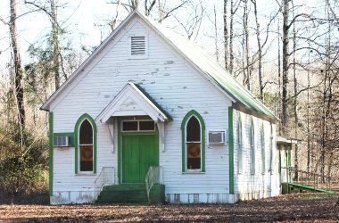 a small white church with a green door