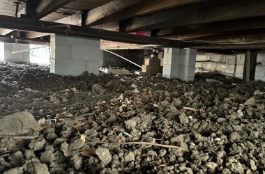 A basement with a lot of dirt in it.
