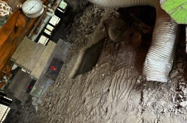 A view of a room with a wooden floor and a pipe.