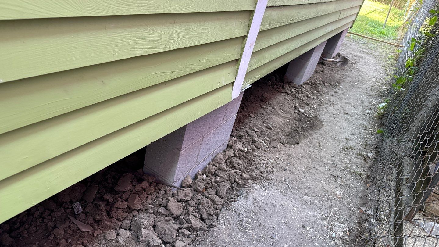 A house with a green siding next to a fence.