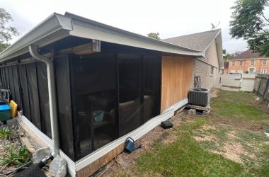 A backyard with a screened in porch.