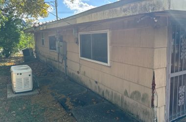 A house with an air conditioner on the side of it.
