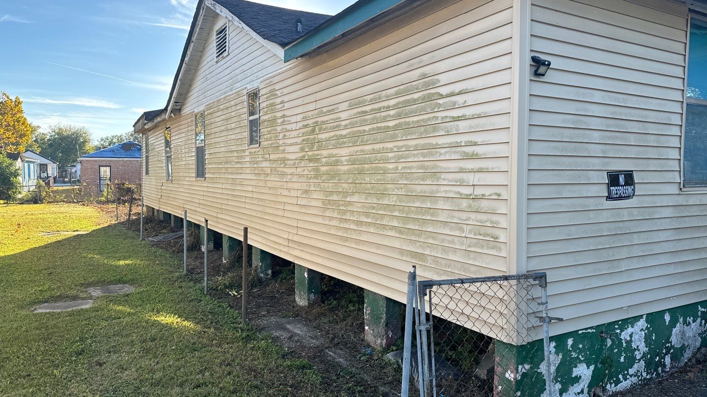 A house with white siding and a fence next to it.