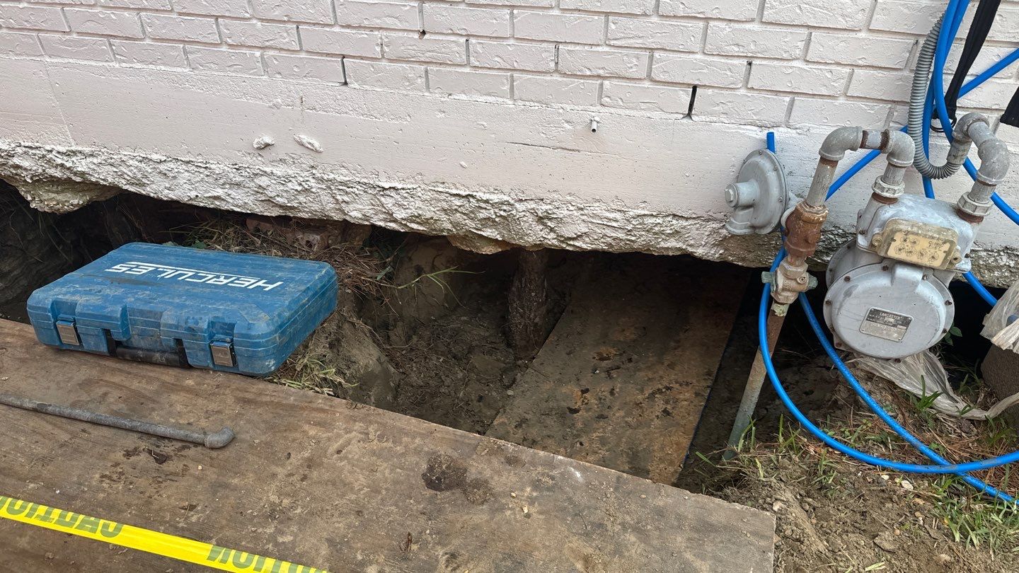 A hole in the ground next to a house.