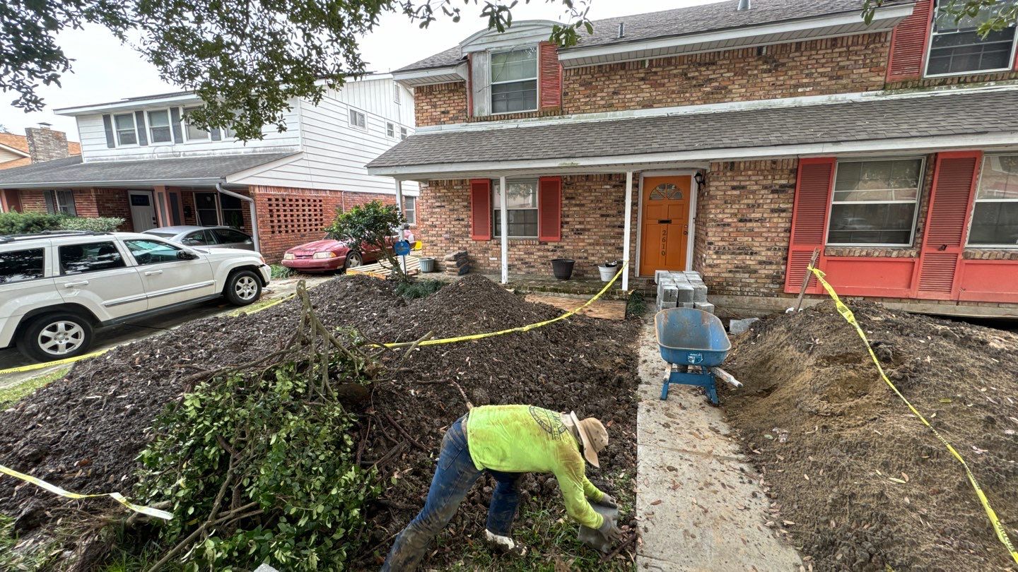 A man is digging a hole in front of a house.