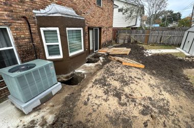 A house with an air conditioning unit in the yard.
