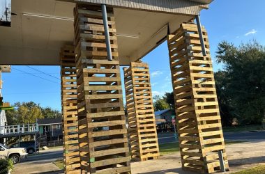 A group of wooden pillars in front of a building.
