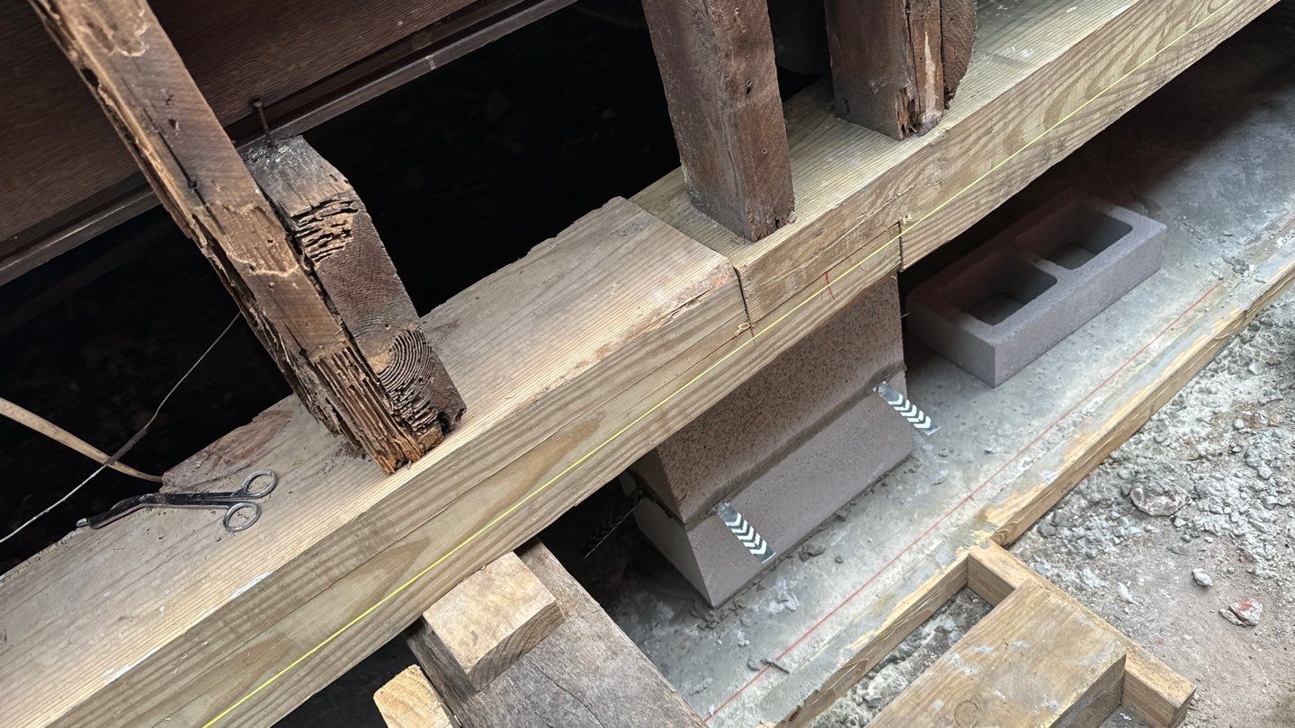 A piece of wood is being used to build a house with a pier and beam foundation.